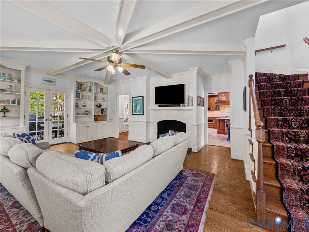 105 Running Cedar Lane, Countryside, Henrico, VA 23229 Vaulted ceiling with decorative beams, wood-finish flooring, built-in floor-to-ceiling cabinetry, and a masonry fireplace