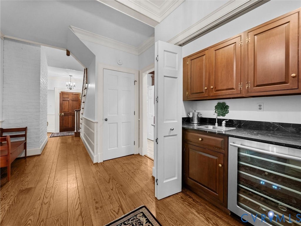 105 Running Cedar Lane, Countryside, Henrico, VA 23229 Wood-finish flooring, custom wood cabinetry, dark stone-finish countertops, built-in wine refrigeration, and white millwork detailing