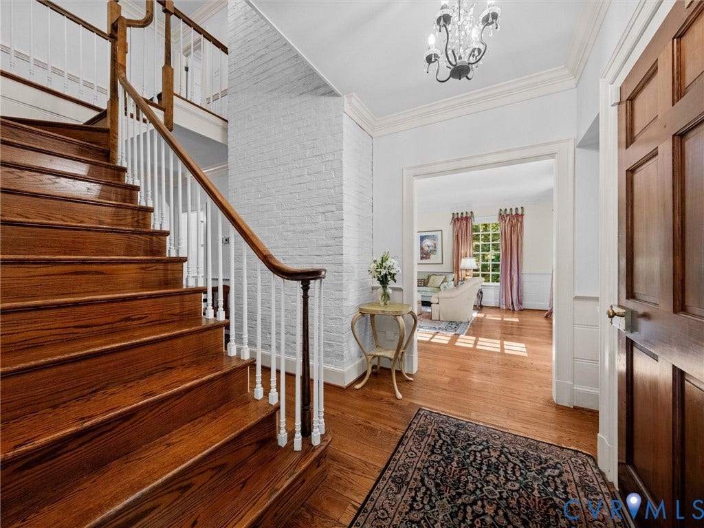 105 Running Cedar Lane, Countryside, Henrico, VA 23229 Foyer featuring a hardwood staircase with a wood handrail, white-painted brick detailing, crown molding, and a suspended chandelier