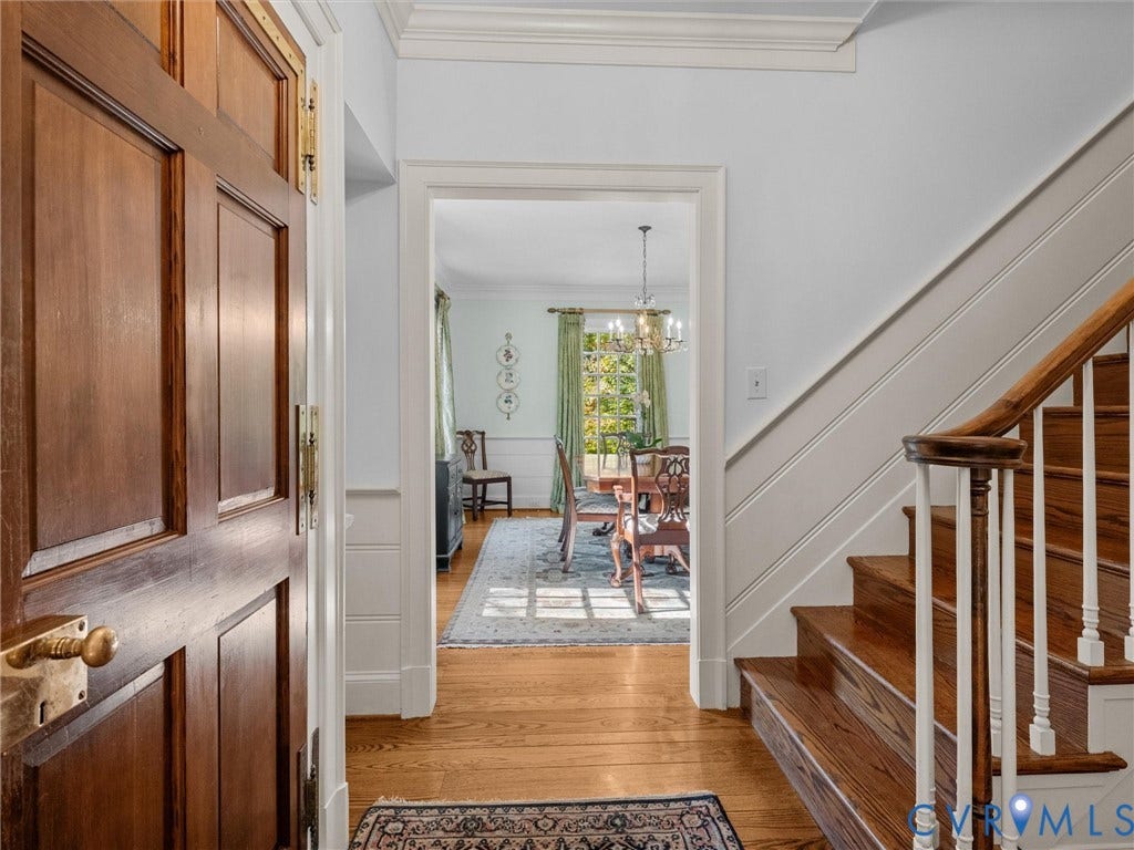 105 Running Cedar Lane, Countryside, Henrico, VA 23229 Foyer entrance featuring a solid wood door with brass hardware, wood-finish flooring, and a staircase with white balusters and a wood handrail