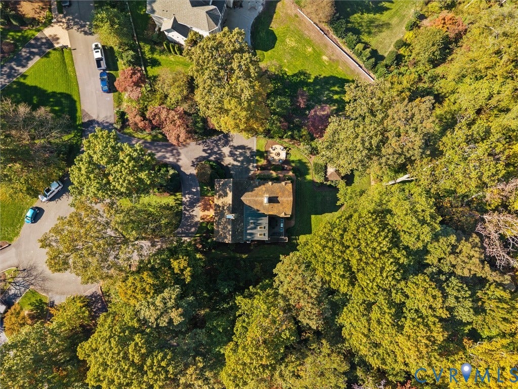 105 Running Cedar Lane, Countryside, Henrico, VA 23229 Aerial perspective of a multi-level structure featuring a shingled roof, asphalt driveway, circular stone patio, and extensive mature tree canopy