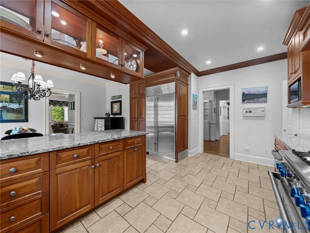 105 Running Cedar Lane, Countryside, Henrico, VA 23229 Kitchen featuring custom wood cabinetry, granite countertops, professional-grade stainless steel refrigerator, stone tile flooring, and integrated display cabinets