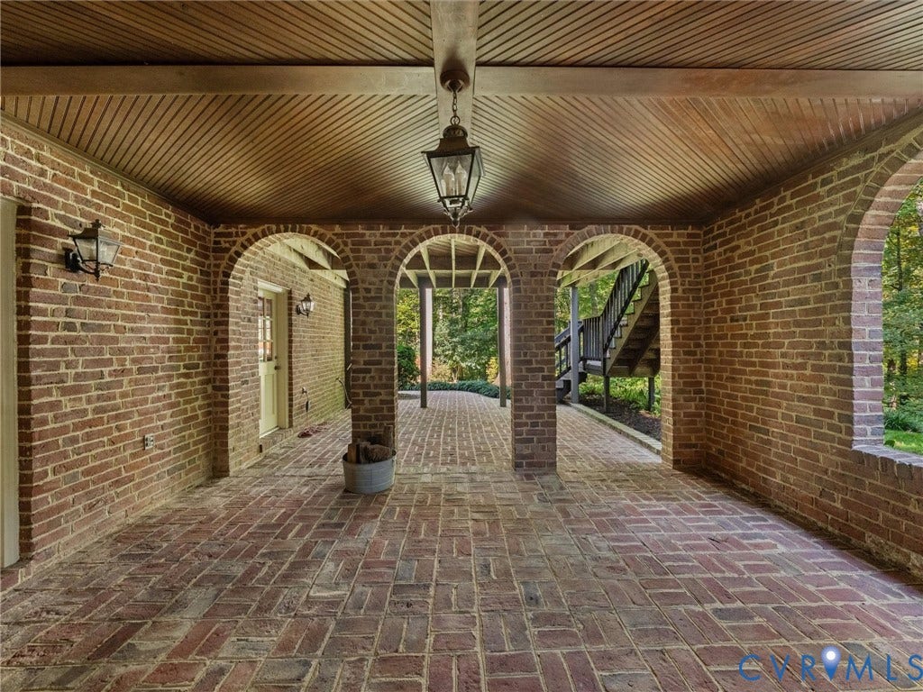 105 Running Cedar Lane, Countryside, Henrico, VA 23229 Covered patio featuring intricate brick archways, a herringbone brick floor, beadboard ceiling, and wall-mounted carriage-style lighting