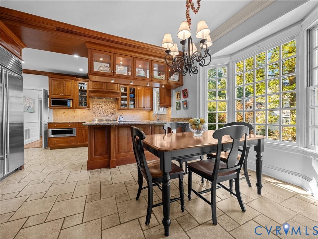 105 Running Cedar Lane, Countryside, Henrico, VA 23229 Kitchen featuring custom wood cabinetry with glass-front uppers, stone-surface countertops, stone tile flooring, a large bay window, and a multi-arm chandelier
