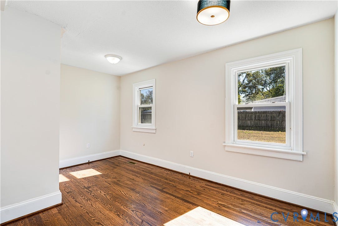 4003 Lee Boulevard, Dinwiddie, VA 23803 Room featuring wood-finish flooring, dual windows with decorative trim, and a drum-style ceiling light fixture