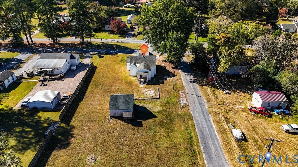 4003 Lee Boulevard, Dinwiddie, VA 23803 Aerial perspective of a property featuring an expansive lot, a standalone storage structure, and a residential building with a pitched shingle roof