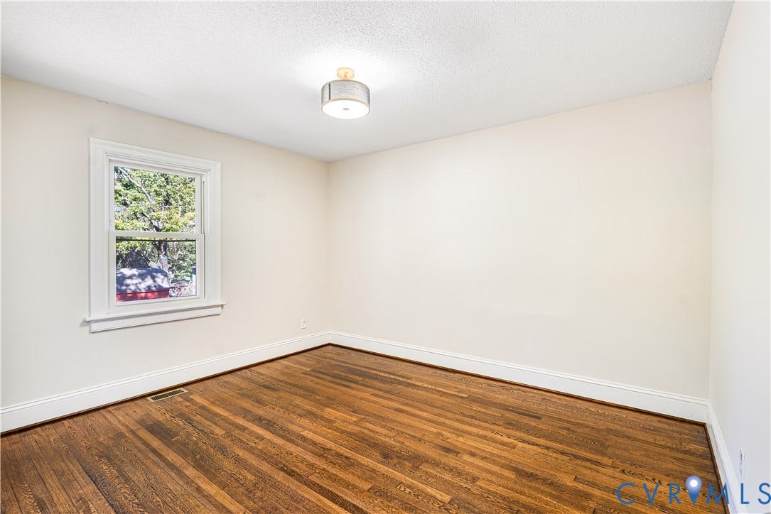 4003 Lee Boulevard, Dinwiddie, VA 23803 Interior room featuring wood-finish flooring, a single-hung window with casing, and a drum-style ceiling light fixture