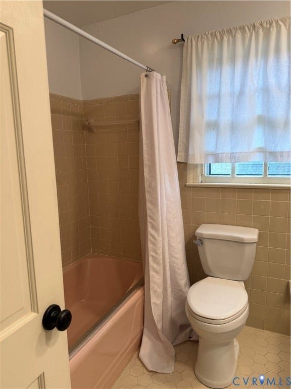 20 Jonquil Lane, Newport News, VA 23606 Bathroom featuring a porcelain tub, neutral-tone wall tiling, hexagon-patterned floor tile, and a multi-pane window