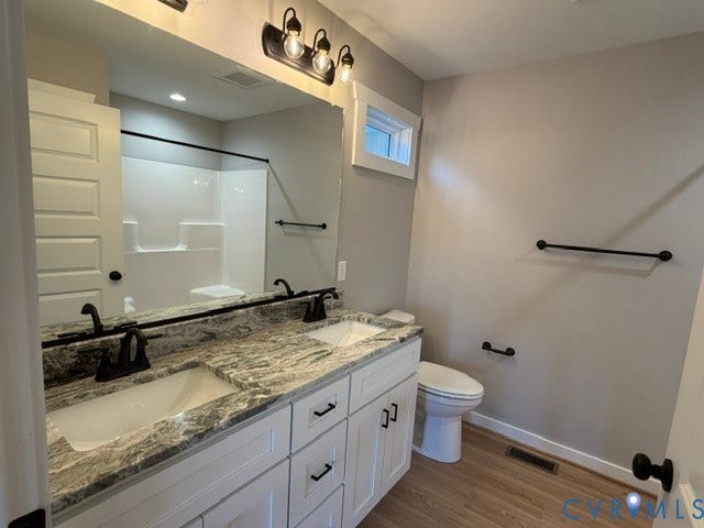 745 Gully Tavern Road, Detached, Rice, VA 23966 Double vanity with stone countertop, undermount sinks, matte black fixtures, white shaker-style cabinetry, and wood-finish flooring