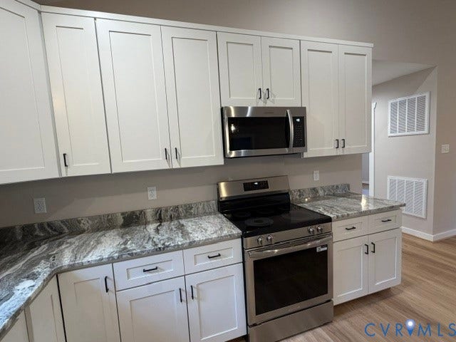 745 Gully Tavern Road, Detached, Rice, VA 23966 White shaker-style cabinetry with matte black hardware, stone-patterned countertops, stainless steel electric range, and stainless steel microwave
