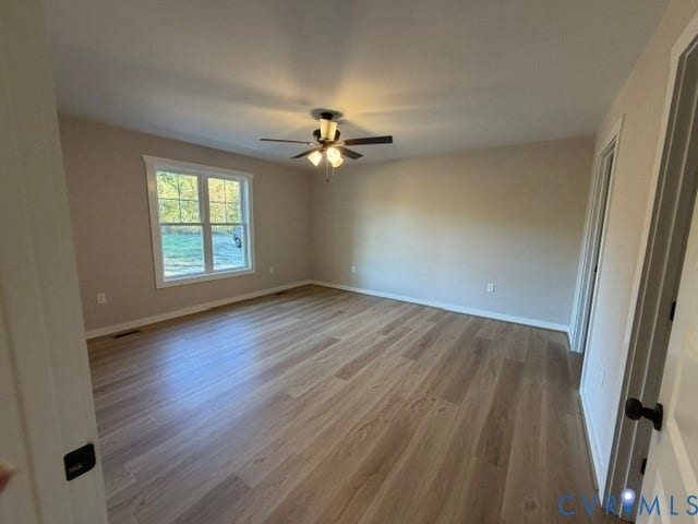 745 Gully Tavern Road, Detached, Rice, VA 23966 Spacious room featuring wood-finish flooring, neutral wall tones, multi-pane window, and a central ceiling fan with multi-light fixture