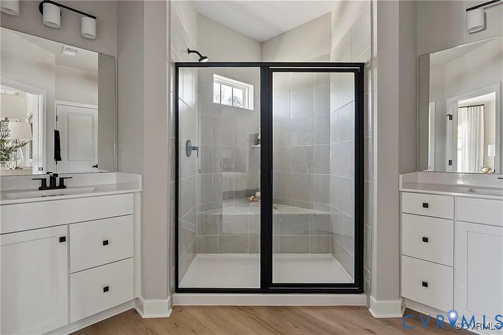 Double vanity with white cabinetry, square undermount sinks, matte black fixtures, and large mirrors