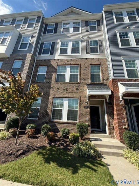 5912 Whitehurst Lane, #B, Henrico, VA 23227 Multi-story brick and siding facade featuring multi-pane windows with shutters, a gabled roofline, and a covered entryway with a concrete walkway