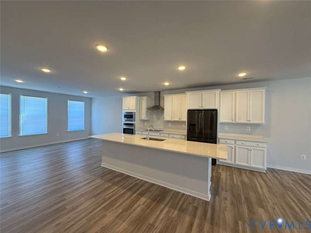 5912 Whitehurst Lane, #B, Henrico, VA 23227 Kitchen featuring a large island with stone-finish countertops, white cabinetry, integrated stainless steel double ovens, recessed lighting, and wood-finish flooring