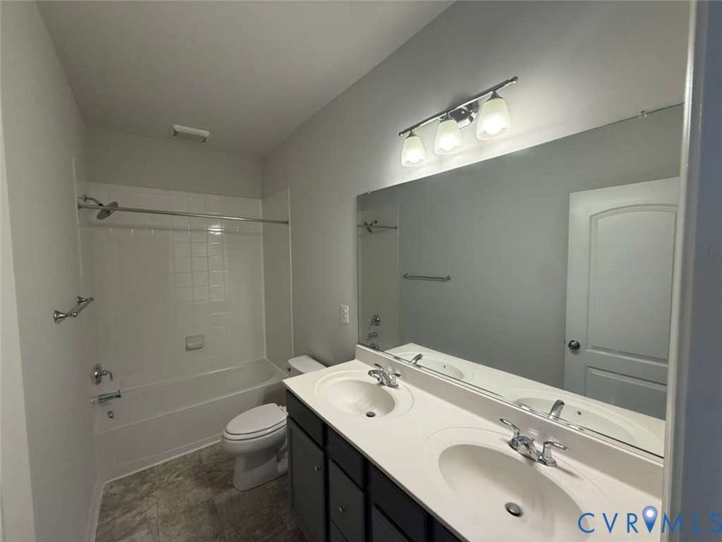 5912 Whitehurst Lane, #B, Henrico, VA 23227 Double vanity with integrated sinks, expansive wall-to-wall mirror, three-bulb vanity lighting, and a combination tub-shower with a tiled surround
