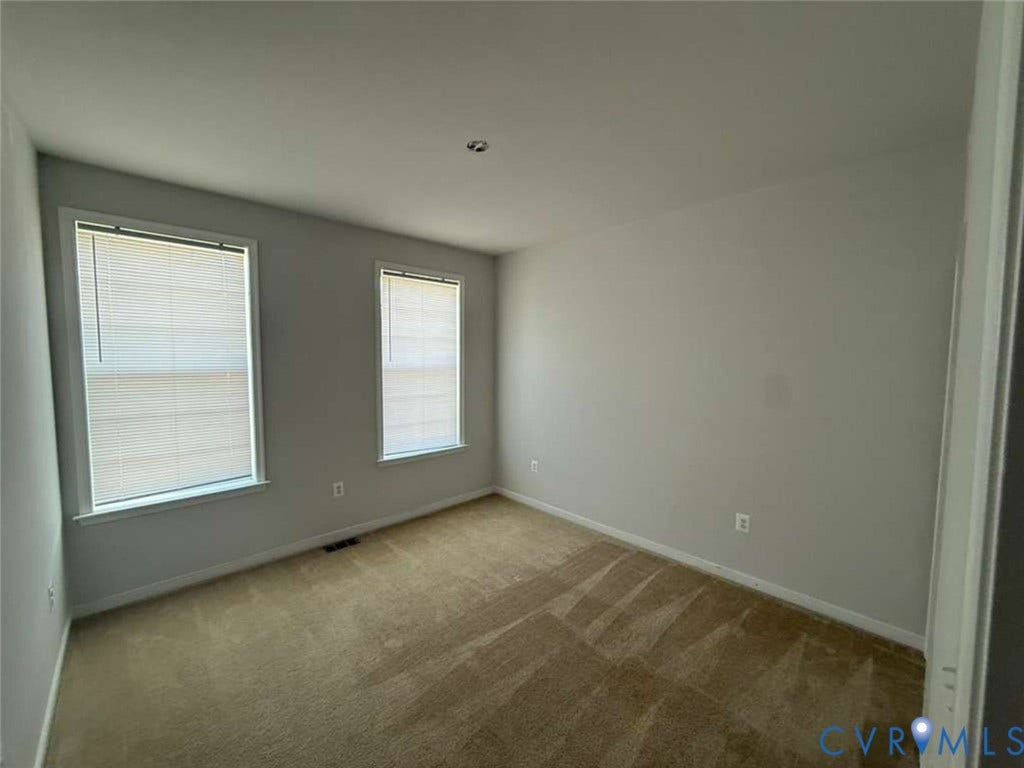 5912 Whitehurst Lane, #B, Henrico, VA 23227 Neutral interior space featuring carpeting, light-toned wall finishes, two windows with integrated blinds, and ceiling-mounted lighting