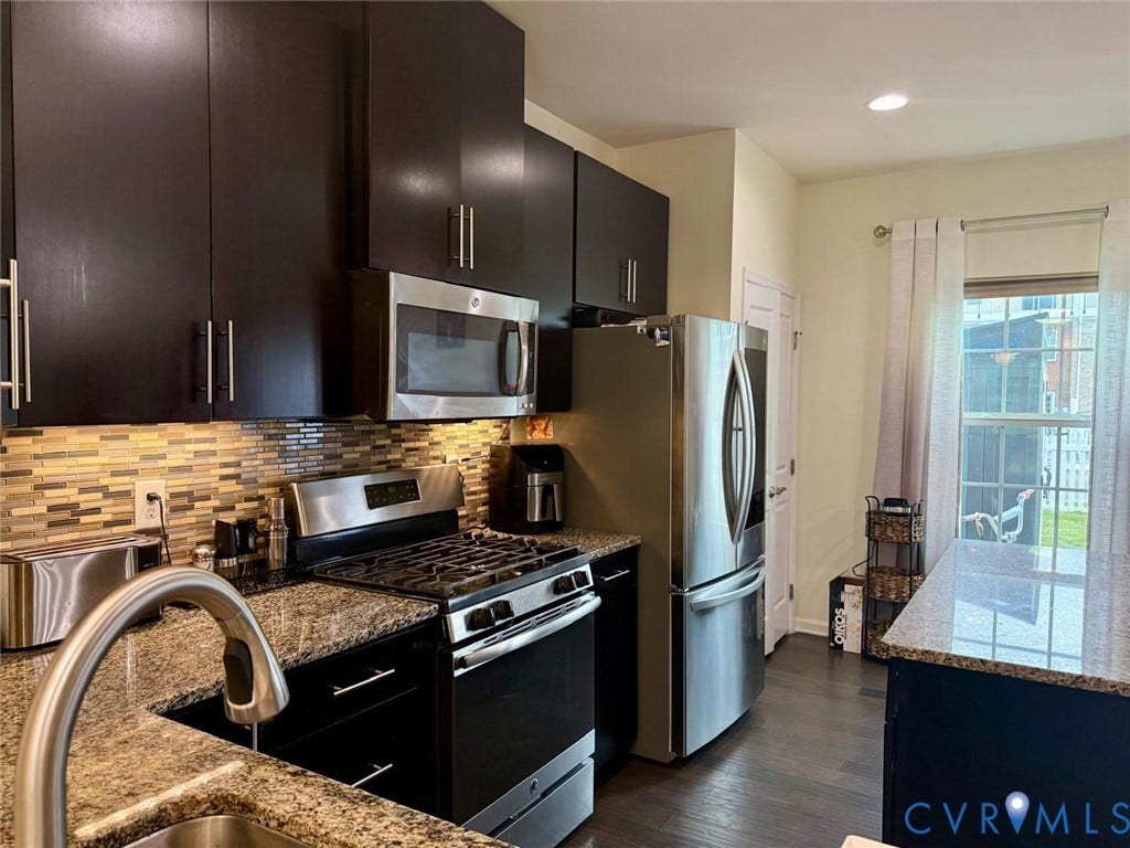 11316 Duncan park Court, Glen Allen, VA 23060 Kitchen featuring dark wood cabinetry, speckled stone countertops, a multi-tonal linear tile backsplash, stainless steel appliances, and wood-finish flooring