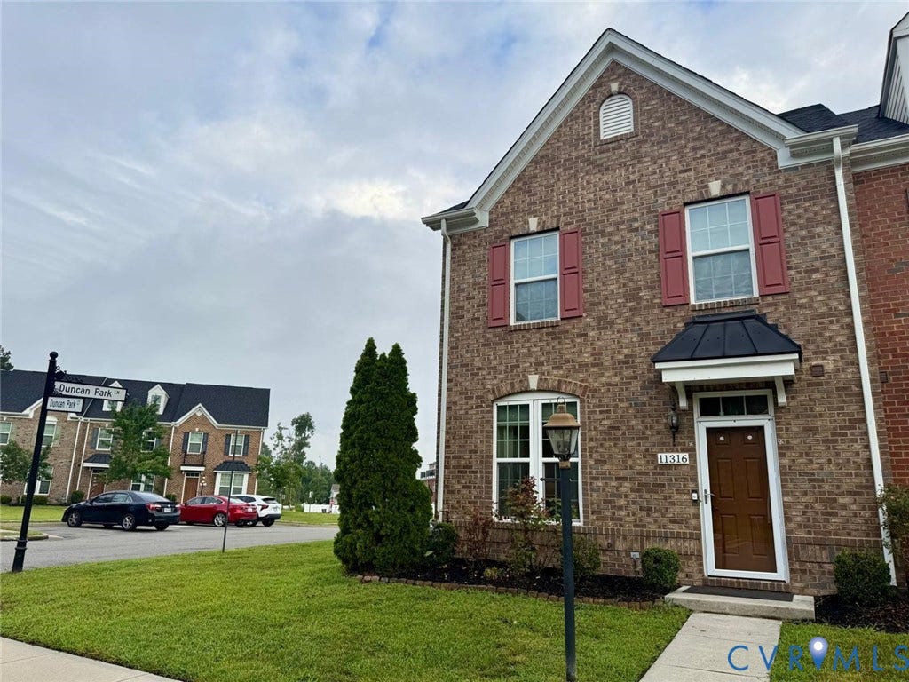 11316 Duncan park Court, Glen Allen, VA 23060 Brick exterior featuring a gabled roofline, decorative window shutters, metal door hood, and transom window above the entrance