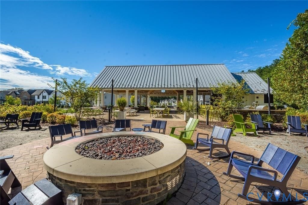 338 Hay Mill Alley, Glen Allen, VA 23060 Outdoor community pavilion featuring a metal roof, stone-clad circular fire pit with a concrete cap, and paver hardscaping