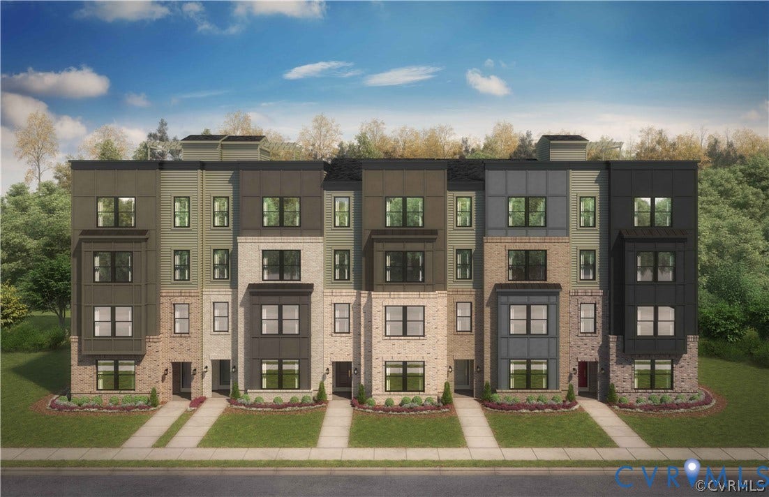Modern multi-story exterior featuring a mix of brick and metal paneling, prominent bay windows, multi-pane fenestration, and dedicated concrete entry paths