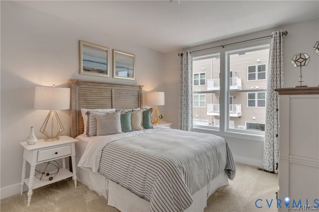 Neutral-toned carpeting, dual-pane windows with grid detailing, and an expansive window configuration