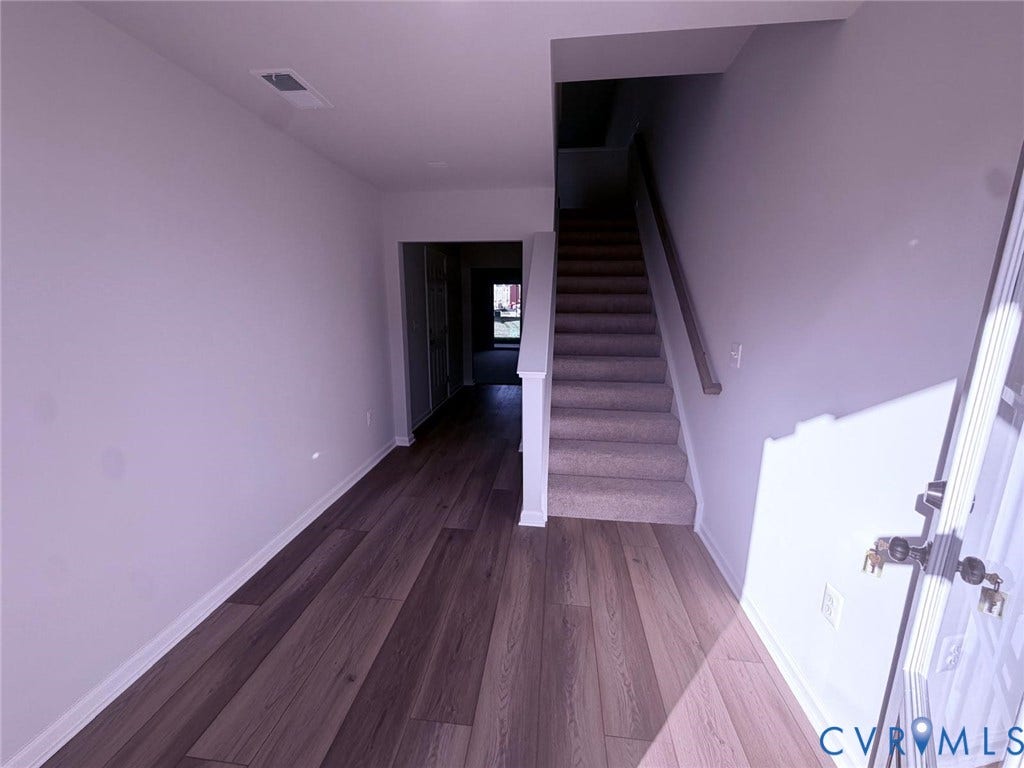 504 Sybil Street, Glen Allen, VA 23060 Entryway featuring wood-finish flooring, a carpeted staircase with a wooden handrail, and neutral wall paint