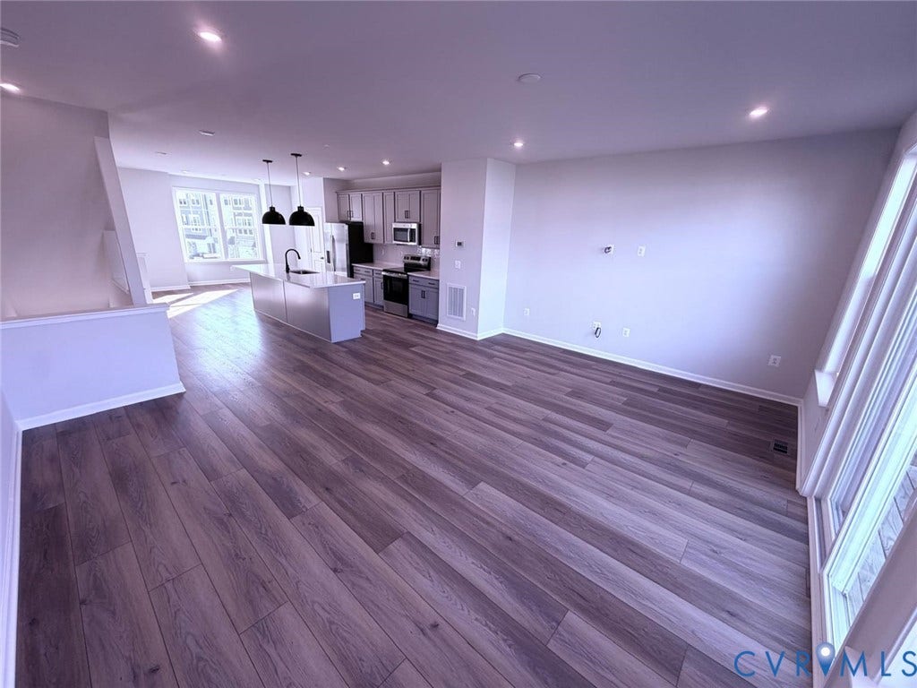 504 Sybil Street, Glen Allen, VA 23060 Open-concept interior featuring wood-finish flooring, a kitchen island with pendant lighting, shaker-style cabinetry, and large windows