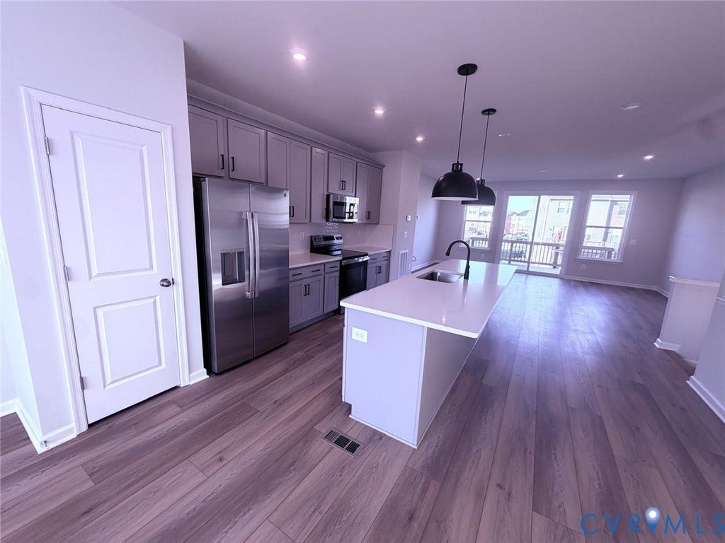 504 Sybil Street, Glen Allen, VA 23060 Kitchen featuring shaker-style cabinetry, quartz countertops, a central island with an integrated sink, stainless steel appliances, and wood-finish flooring