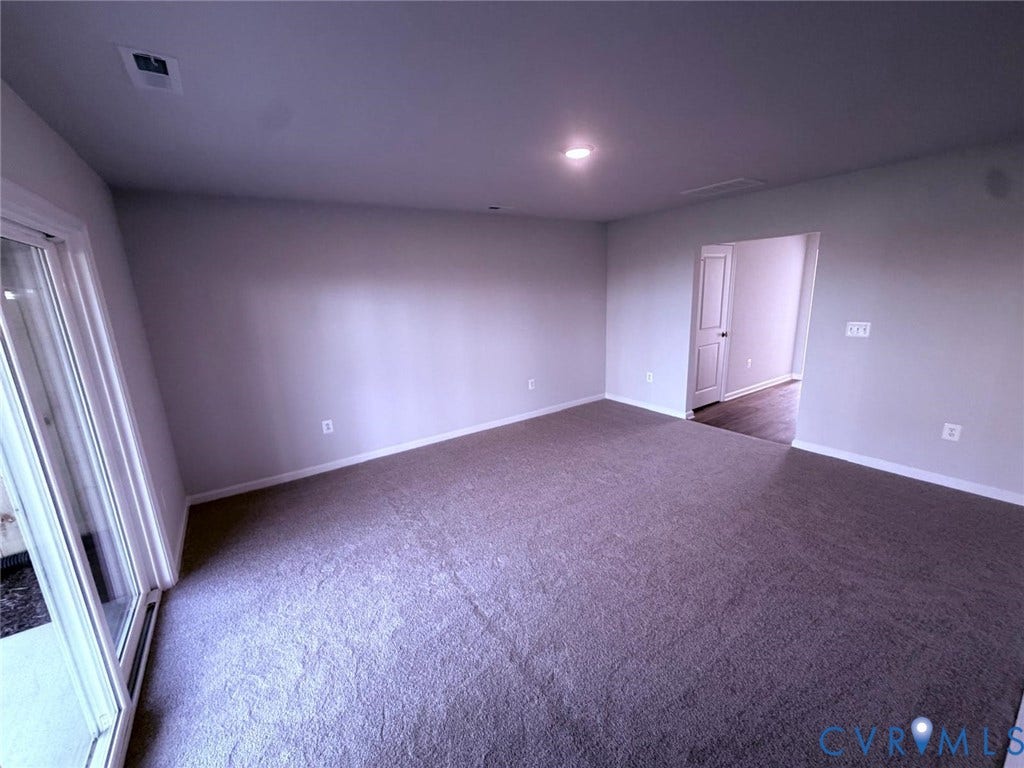 504 Sybil Street, Glen Allen, VA 23060 Neutral-toned interior space featuring wall-to-wall carpeting, sliding glass doors, recessed lighting, and a multi-panel interior door