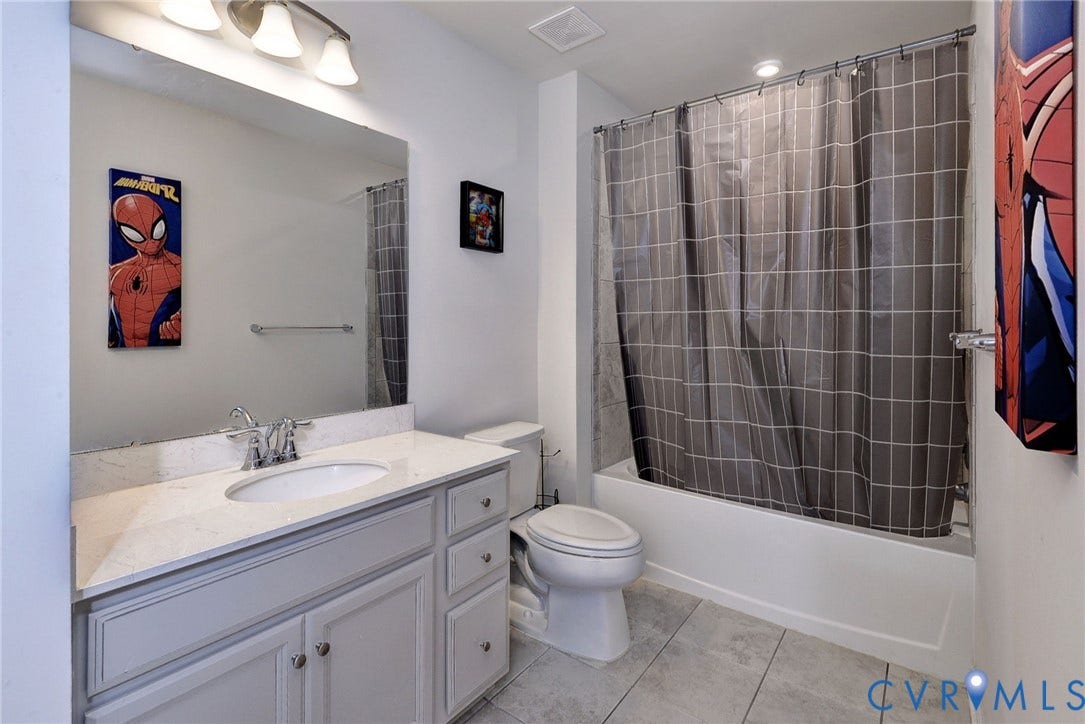 3415 Foxglove Drive, Toano, VA 23168 Bathroom featuring a vanity with stone-finish countertop, undermount sink, chrome faucet, large-format tile flooring, and a shower-tub combination