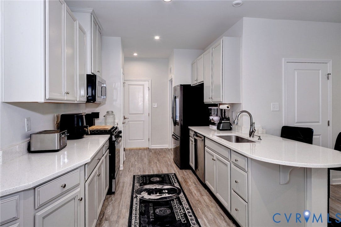 3415 Foxglove Drive, Toano, VA 23168 Kitchen featuring white shaker-style cabinetry, solid-surface countertops, wood-finish flooring, a stainless steel undermount sink, and recessed lighting