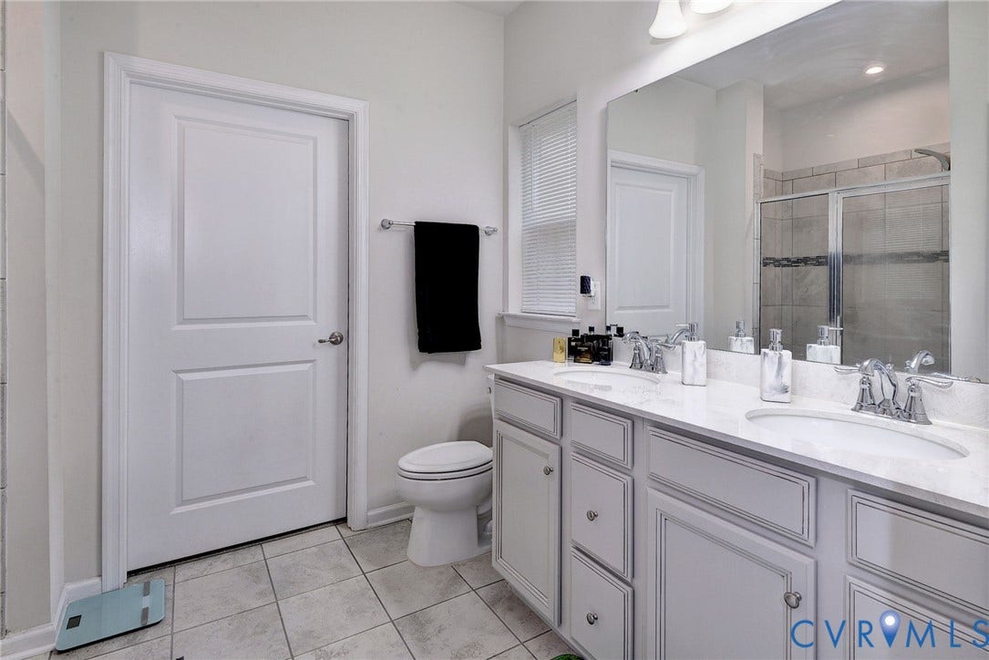 3415 Foxglove Drive, Toano, VA 23168 Bathroom featuring a dual-sink vanity with light-toned cabinetry, light-colored countertops, polished chrome fixtures, a large wall-mounted mirror, and tile flooring