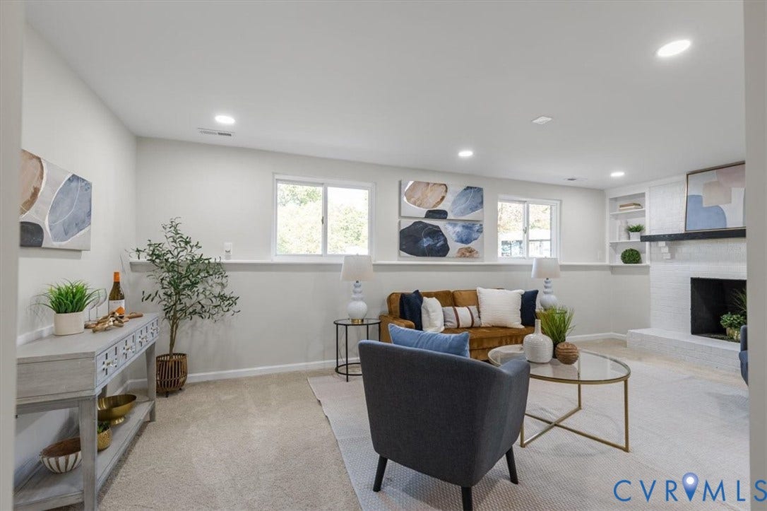 9201 Packard Court, Glen Allen, VA 23060 Living area featuring neutral carpeting, recessed lighting, horizontal windows with integrated sills, and a fireplace with a white brick surround and wood mantel