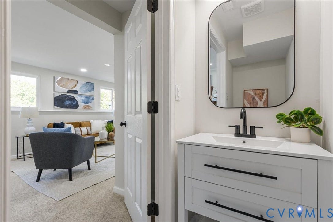 9201 Packard Court, Glen Allen, VA 23060 White vanity featuring quartz countertop, rectangular basin, matte black faucet, and hardware, complemented by a rounded mirror