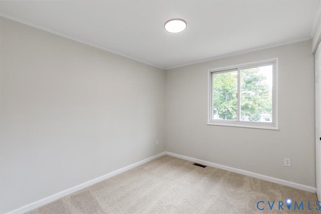 9201 Packard Court, Glen Allen, VA 23060 Neutral-toned interior room featuring wall-to-wall carpeting, a sliding window with exterior greenery, and a flush-mount overhead light fixture