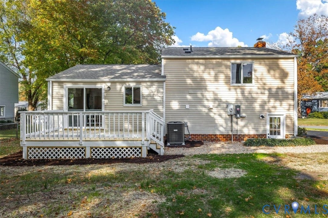 9201 Packard Court, Glen Allen, VA 23060 Rear exterior featuring light-toned horizontal siding, a white wooden deck with lattice skirting, sliding glass doors, and a brick foundation trim