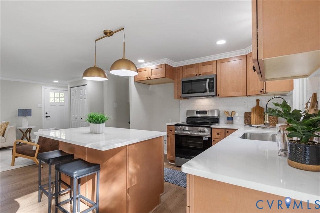 9201 Packard Court, Glen Allen, VA 23060 Kitchen featuring wood cabinetry, white stone-finish countertops, subway tile backsplash, a central island, and matte metallic pendant lighting