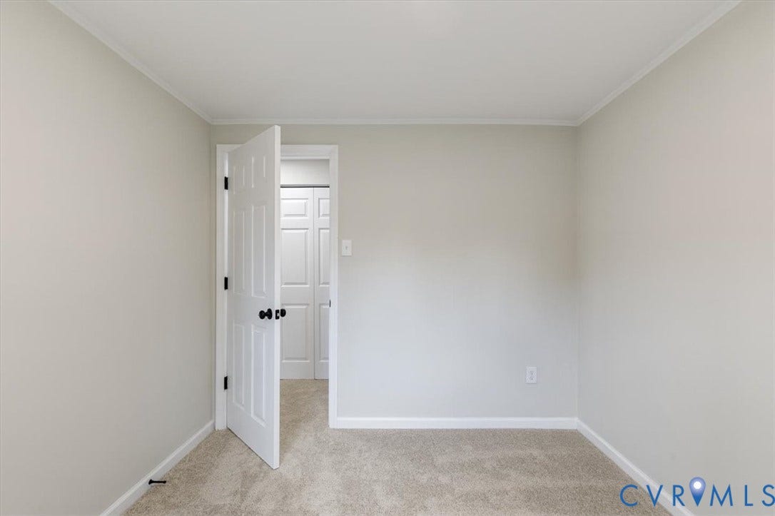9201 Packard Court, Glen Allen, VA 23060 Neutral-toned interior space featuring wall-to-wall carpeting, a six-panel interior door with matte black hardware, and double-door closet storage