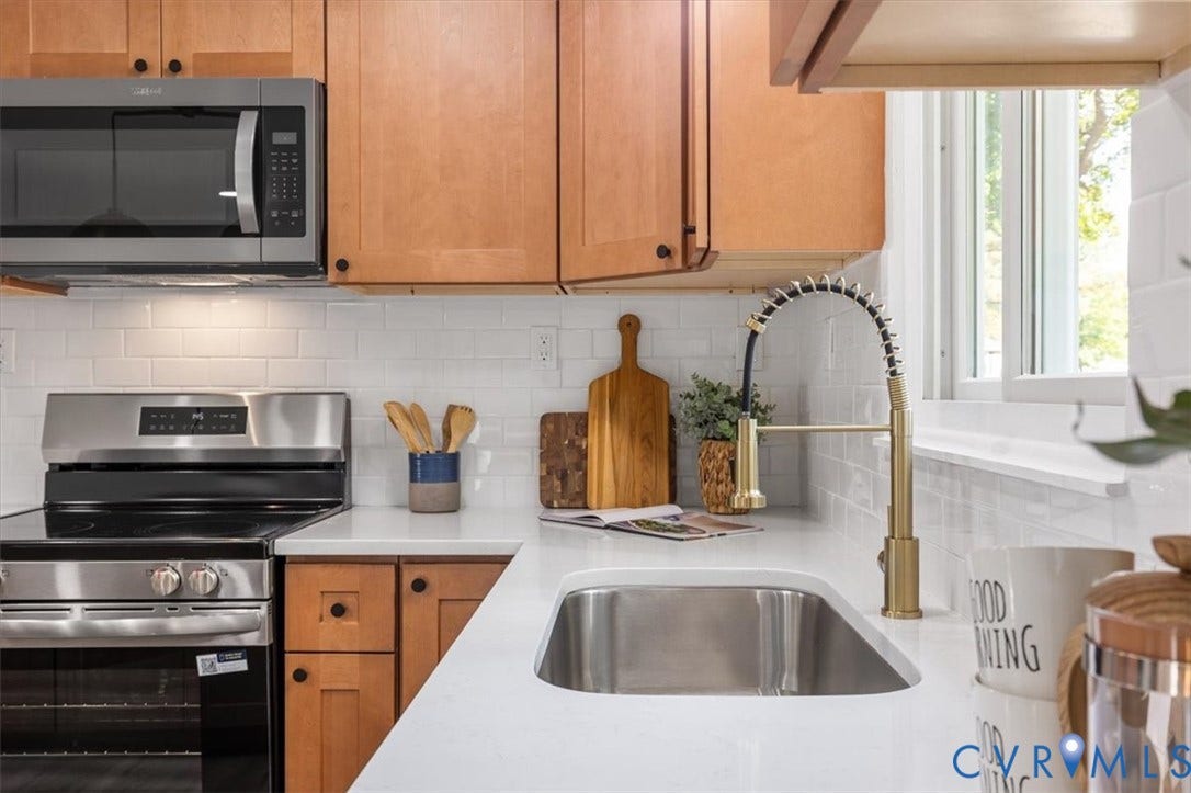 9201 Packard Court, Glen Allen, VA 23060 Kitchen featuring wood cabinetry, white quartz countertops, subway tile backsplash, stainless steel appliances, and a gold-finish arched faucet