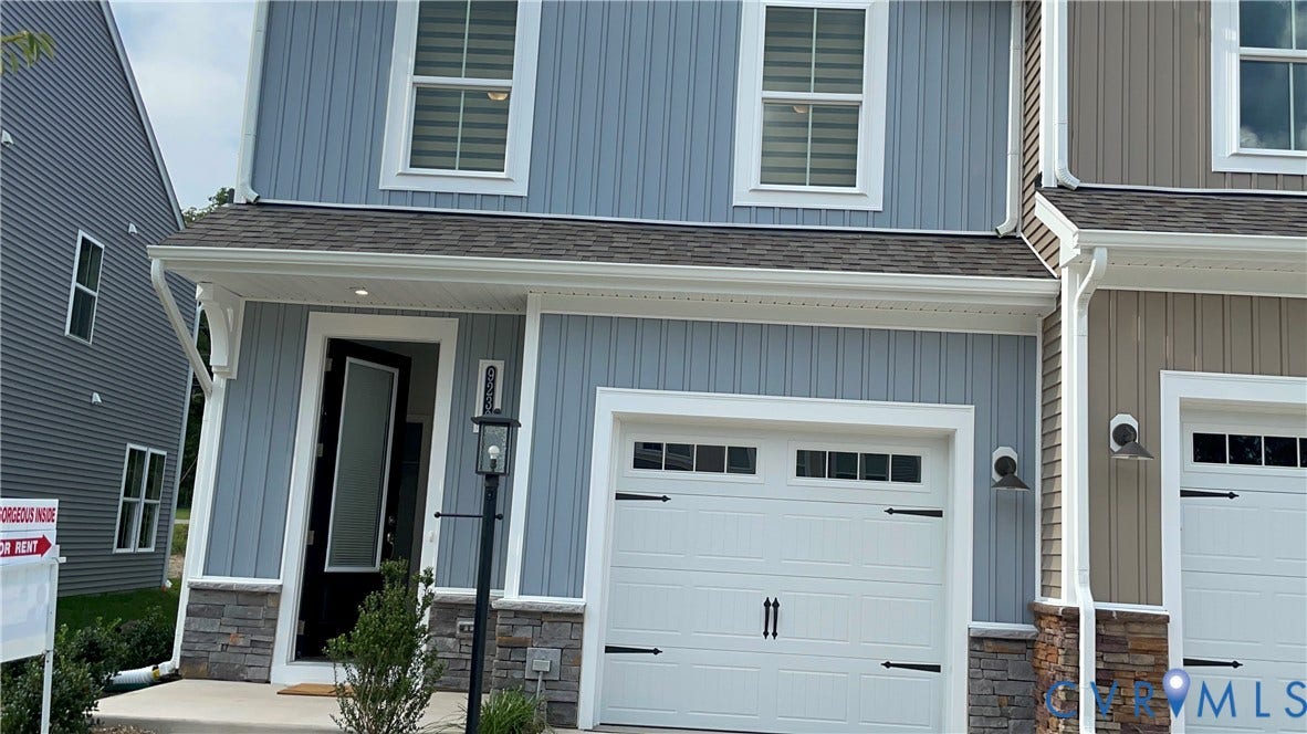 9212 St Charles Circle, Richmond, VA 23235 Vertical board-and-batten siding with stone veneer base, single-car garage featuring carriage-style hardware, and covered front entryway