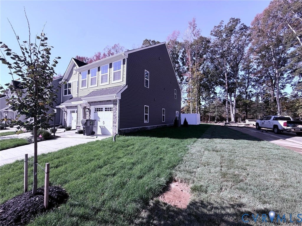 10600 Pink lily Lane, Chesterfield, VA 23234 Exterior elevation featuring multi-tone horizontal siding, stone veneer accents, an attached two-car garage, and a sodded lawn