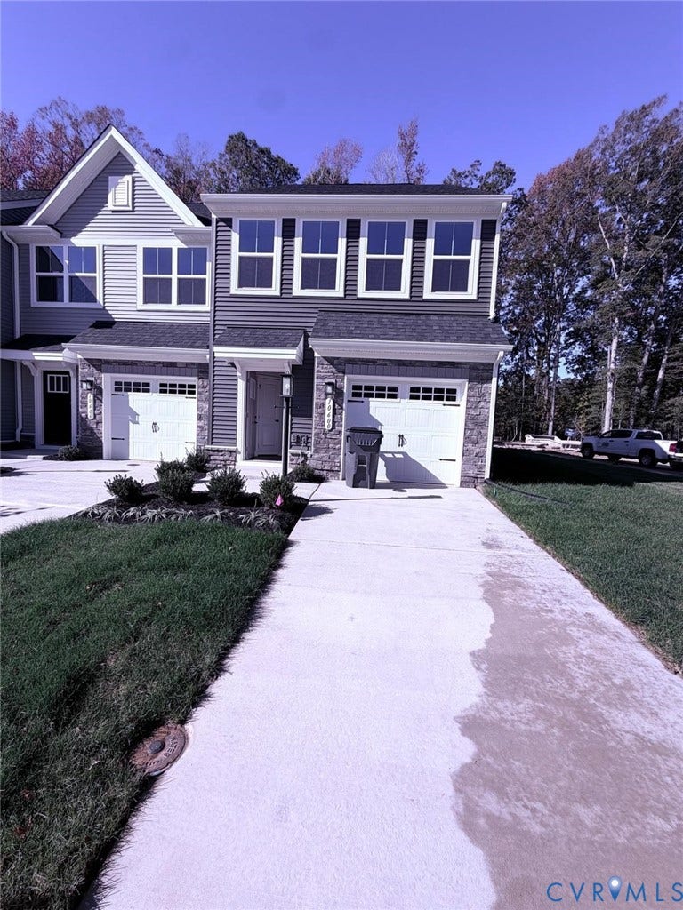 10600 Pink lily Lane, Chesterfield, VA 23234 Townhome exterior featuring horizontal siding, stone veneer accents, a concrete driveway, and attached single-car garages