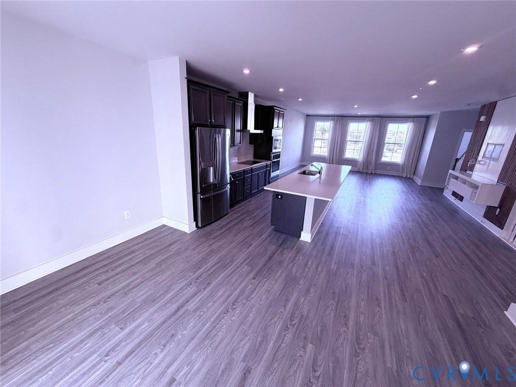 4411 GREYBULL Walk, #B, Glen Allen, VA 23233 Kitchen featuring dark wood cabinetry, stainless steel appliances, a center island with a stone-finish countertop, and wood-finish flooring