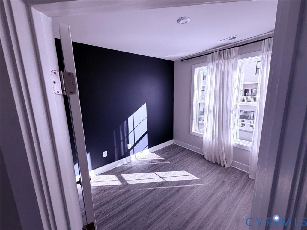 4411 GREYBULL Walk, #B, Glen Allen, VA 23233 Interior space featuring wood-finish flooring, a dark accent wall, and double-pane windows