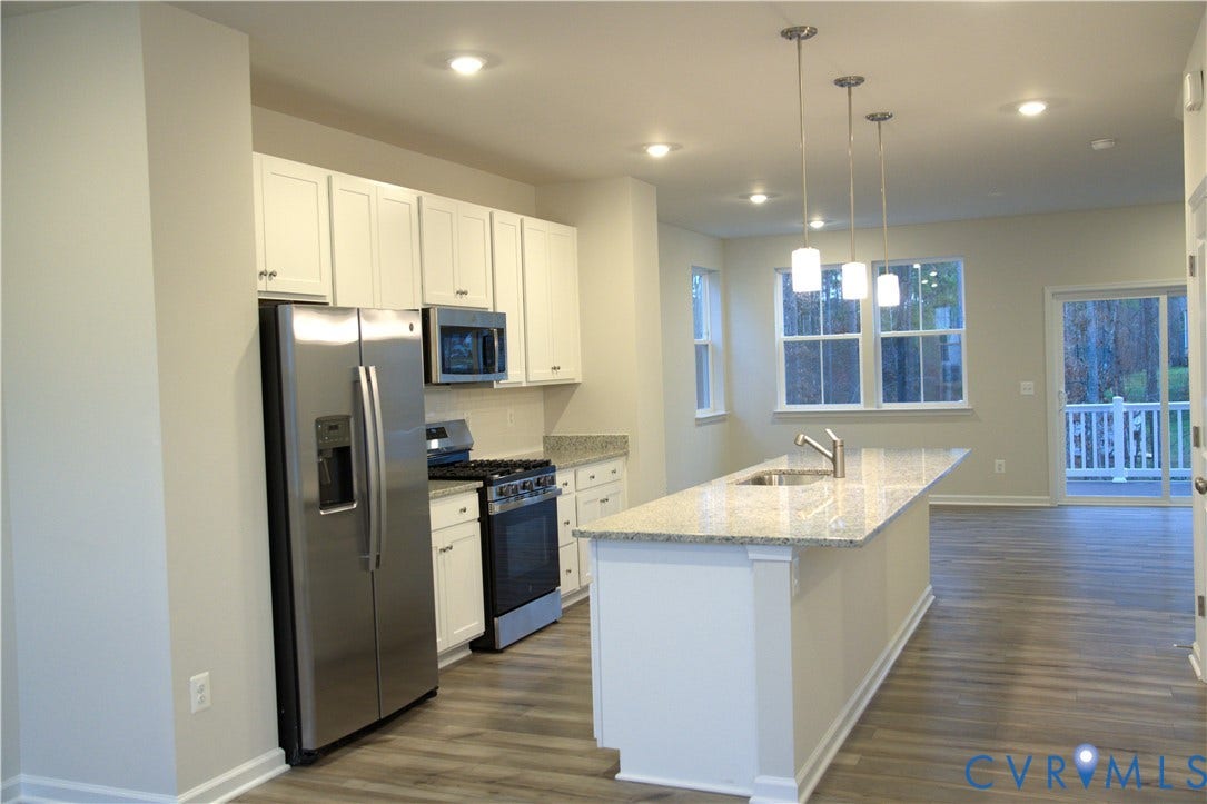 16005 Abelson Way, Chesterfield, VA 23832 Kitchen featuring white cabinetry, stone-finish countertops, stainless steel appliances, a center island with a built-in sink, and wood-finish flooring
