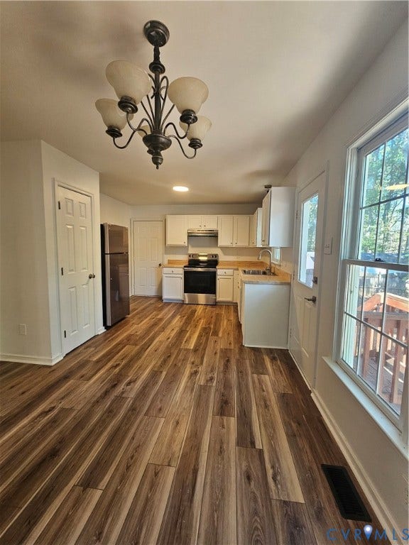 1219 Amber Forest Drive, Midlothian, VA 23114 Kitchen featuring wood-finish flooring, white cabinetry, stainless steel appliances, and a decorative five-light chandelier