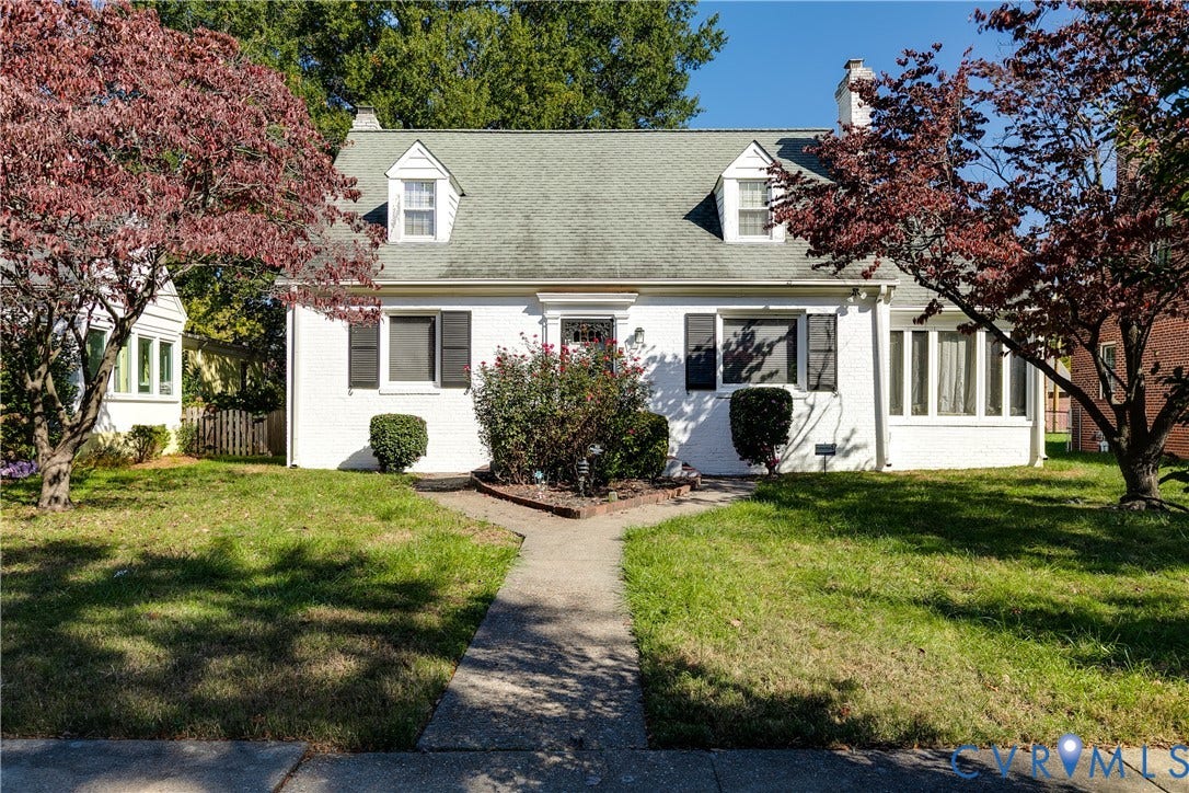 1406 Wentbridge Road, Richmond, VA 23227 Cape Cod exterior featuring painted brick masonry, two dormer windows, dark exterior shutters, and a central chimney