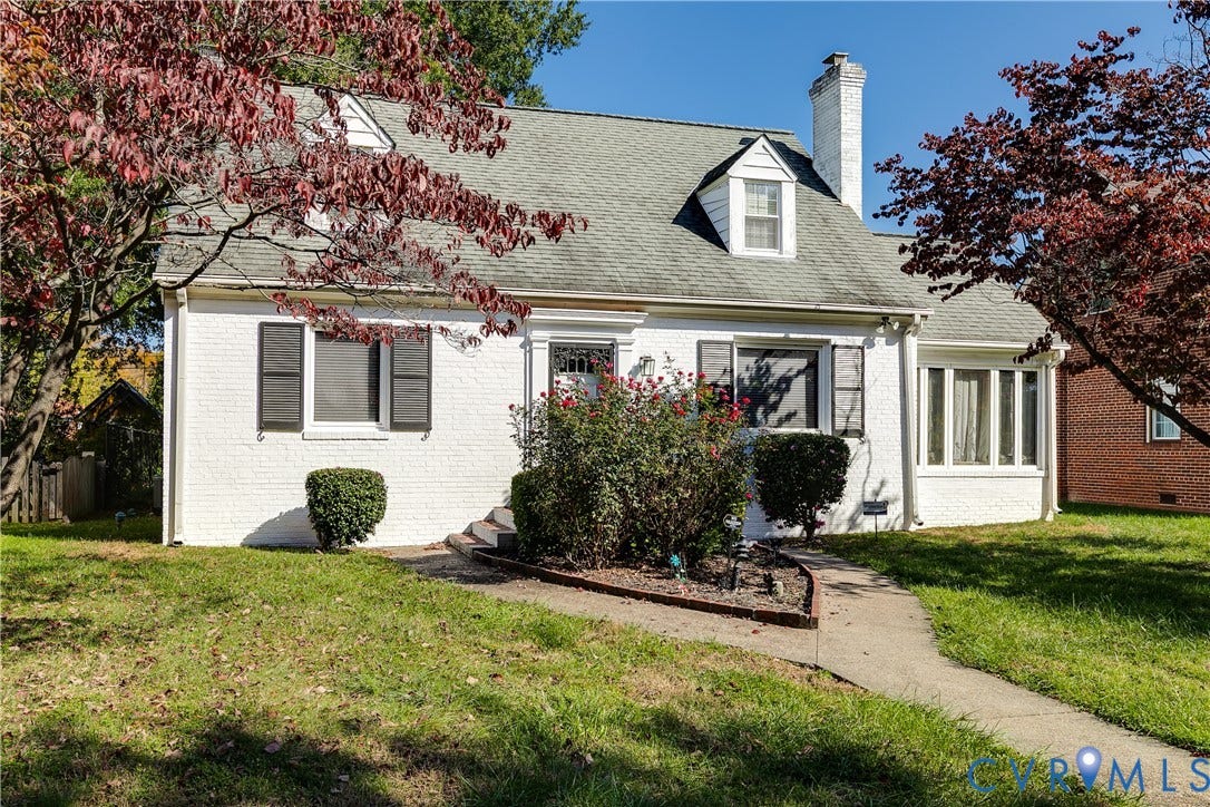 1406 Wentbridge Road, Richmond, VA 23227 White-painted brick exterior featuring a steep-pitched roof, brick chimney, dormer windows, and decorative shutters