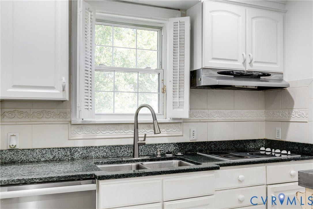 1406 Wentbridge Road, Richmond, VA 23227 Kitchen featuring white cabinetry, stone-surface countertops, dual-basin stainless steel sink with high-arc faucet, integrated stainless steel range hood, and tile backsplash with decorative inset detailing