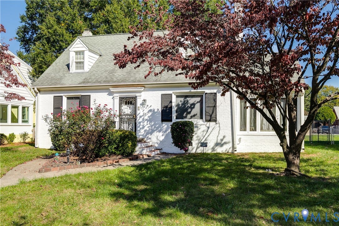 1406 Wentbridge Road, Richmond, VA 23227 Painted brick exterior featuring dark shutters, a front gable dormer, and an arched entryway